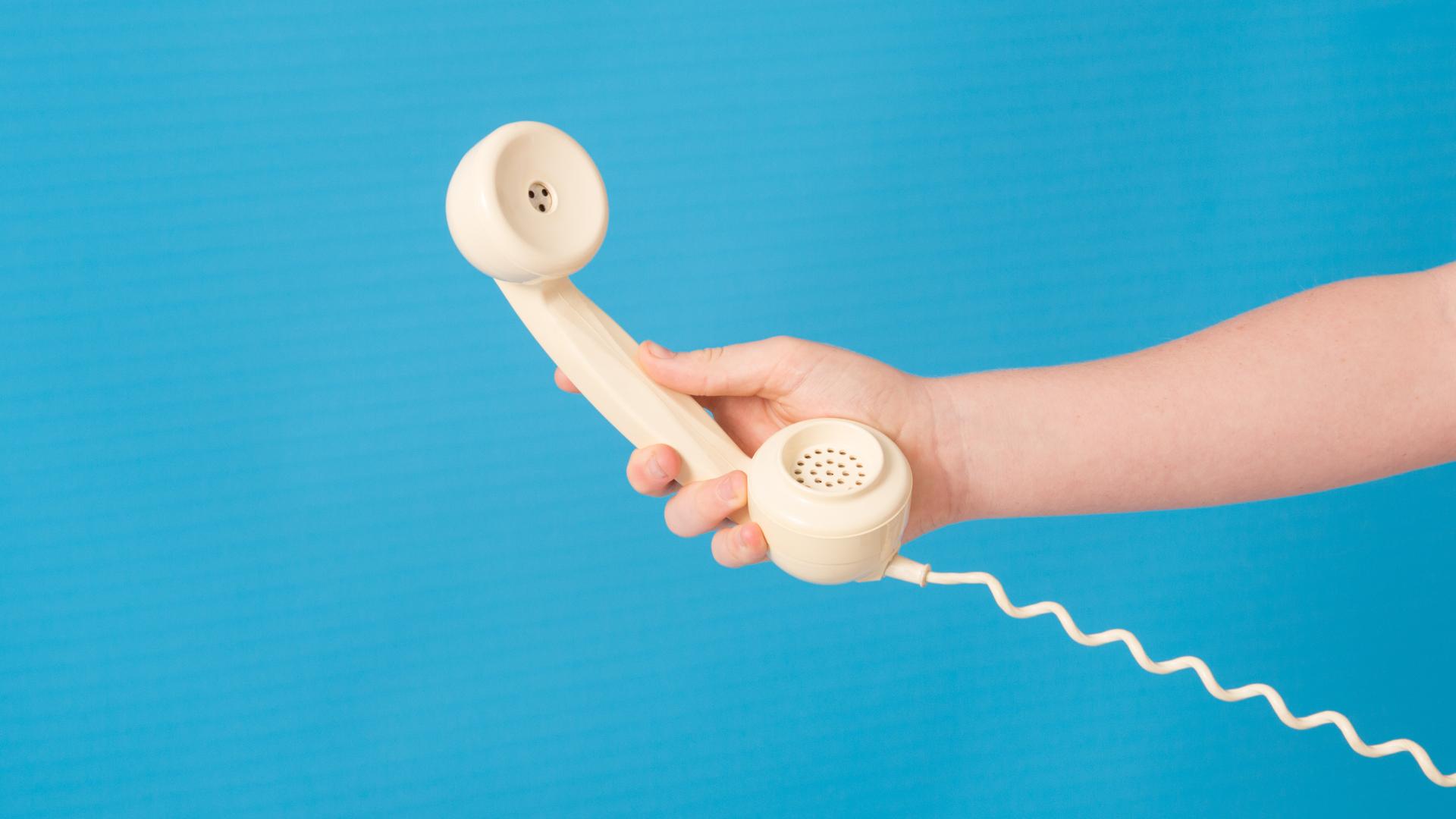 An image of a person handing an old telephone.